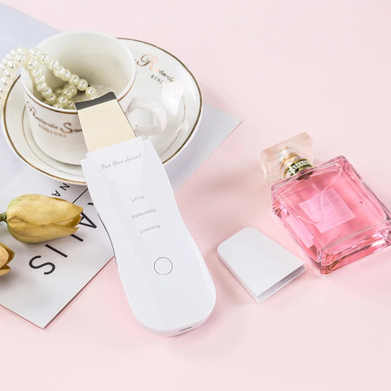 Vibrating facial cleansing spatula held in hand for scale